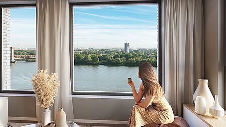 Impressie vrouw in appartement in gebouw Stockholm. Ze geniet van het uitzicht over de rivier.