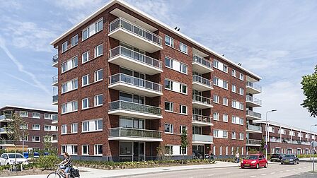 Gebouw met appartementen in Stella Nova. Met bruine bakstenen en grote, witte balkons.