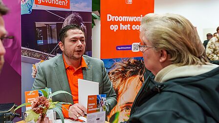 Mensen in gesprek over nieuwbouw tijdens de Woonmarkt Nissewaard.