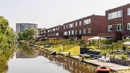 Woningen aan het water in fase 1 van Stella Nova in Spijkenisse. Met warme kleuren en platte daken.