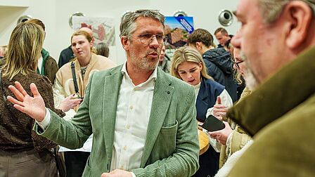 Mensen met elkaar in gesprek over een nieuwbouwproject op de Woonmarkt Nissewaard.