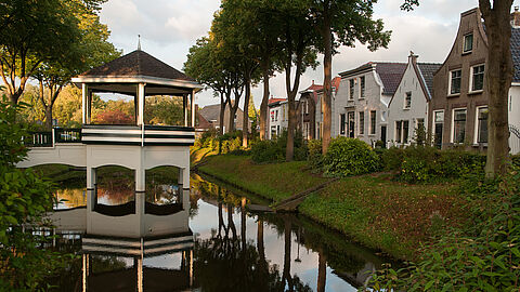 Ring in Abbenbroek, met water, muziektent en oude gevels.