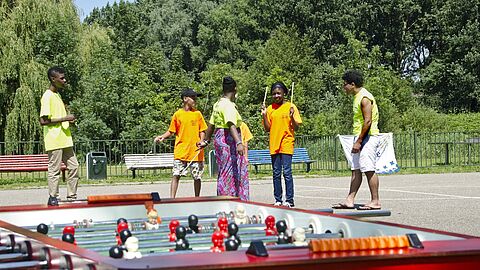 Jongeren op pleintje met tafelvoetbal in de wijk Schiekamp-Hoogwerf in Spijkenisse
