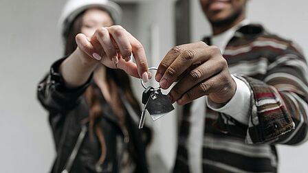 Jonge woningkopers laten de sleutel van hun nieuwe huis zien.