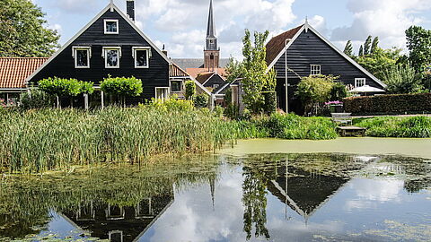 Blik op Geervliet, met water, gevels met zwart hout en de kerktoren.