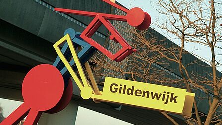 Metrospoor langs de Gildenwijk, met naambord van de wijk zelf.