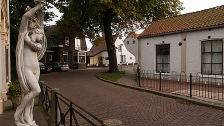 De Ring in Simonshaven, met oude gevels en een beeld.