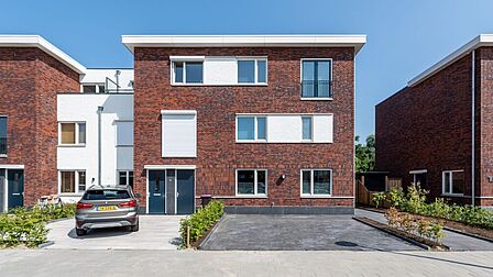 Twee-onder-één-kapwoningen uit de eerste fase van Stella Nova in Spijkenisse. Met warme kleuren en platte daken.