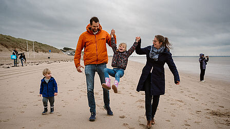 Wandelaars met hond op het strand bij Rockanje.